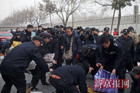 警方联合城管正查扣路边摊位售卖物品。新京报记者 周岗峰 摄