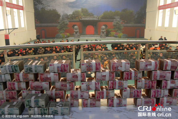 2015年12月19日，在河北保定市望都县的恒业合作社，长桌上摆放好的1000多万现金。图片来源：陈卫红马立方/视觉中国