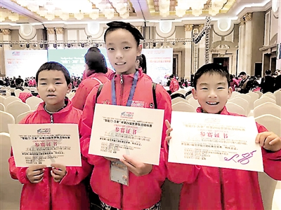 三个孩子在世界脑力锦标赛上合影，从左至右：12岁的陈龙豪、13岁的曾靖雅、9岁的朱宇凡。