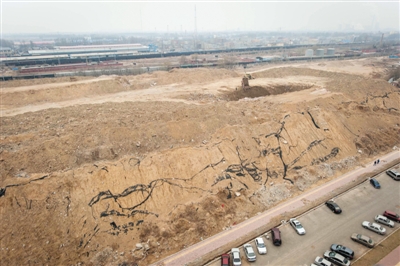 2013年，北京市朝阳区“远洋一方”小区外7层楼高的渣土山上，渣土车正在倾倒建筑垃圾。 新京报资料图片
