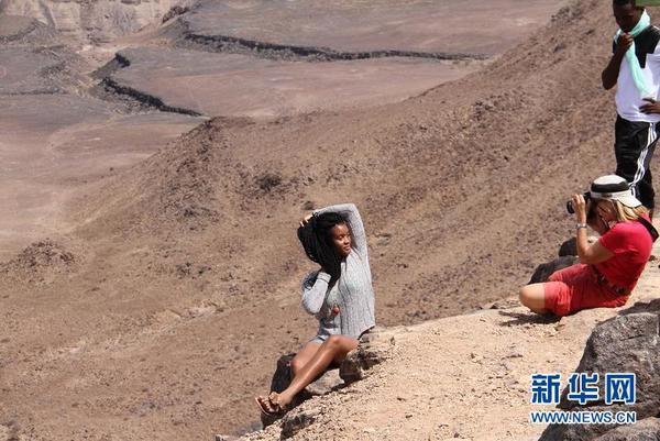 图为12月25日游客在鱼河峡谷的悬崖边上拍照。新华社记者吴长伟摄