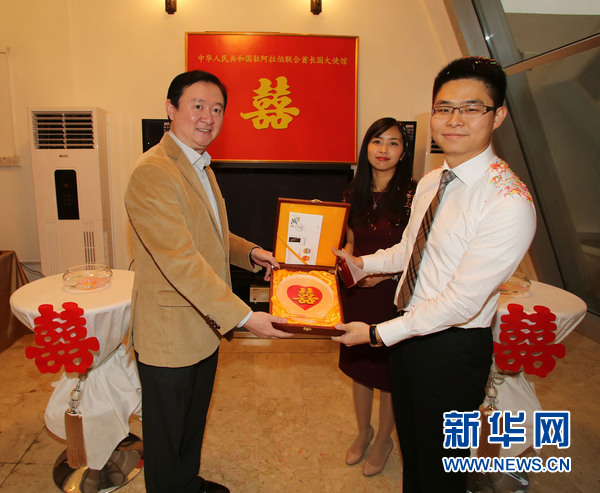 常华大使（左）向新郎新娘赠送纪念品。新华社记者安江 摄