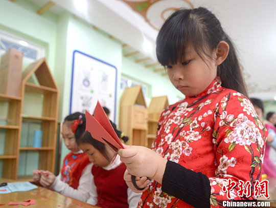 图为学生们身着中式传统服装在学剪纸。中新社记者 魏颖 摄