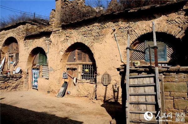 架子车、土窑洞、土黄色调构成了陕北窑洞民居的特色。张龙摄