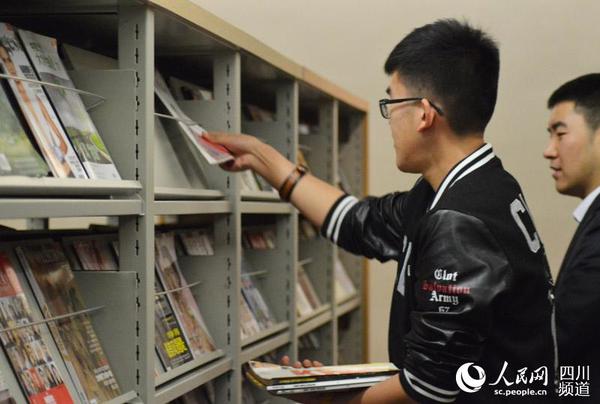 图为杨靖维将期刊上架。王波 摄