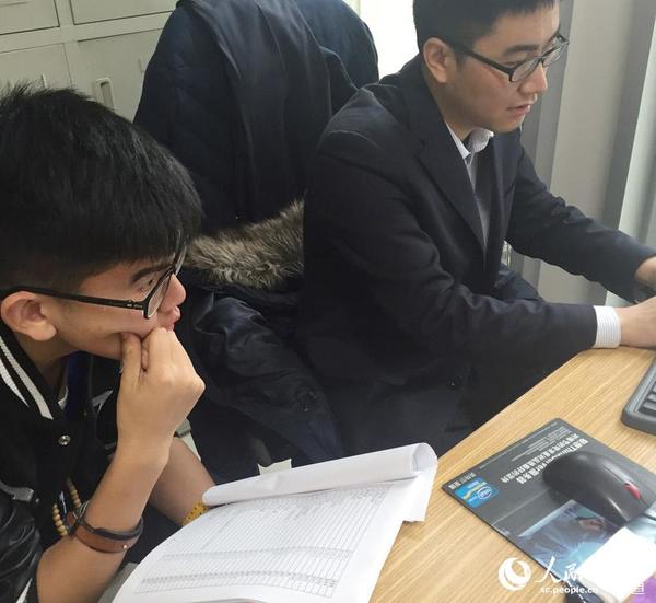 图为杨靖维配合工作人员打印标签。周栩如 摄