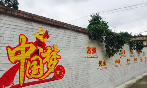 河大学生下乡画文化墙 展现核心价值观绘出中国梦。资料图