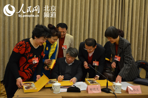 郑晓龙为委员们签名留念。人民网尹星云 摄