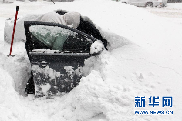 1月23日，在美国纽约曼哈顿，一名男子清除汽车上的积雪。新华社记者李木子摄