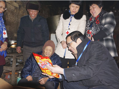 广西壮族自治区靖西市新甲乡垌平村，王汝鹏为老人送上慰问品。