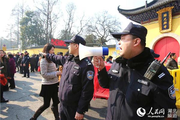 归元寺门前民警用小喇叭引导人流有序入寺