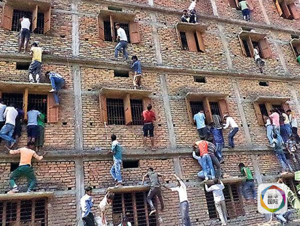 家长爬上教室外墙,给室内的学生递送试卷答案。