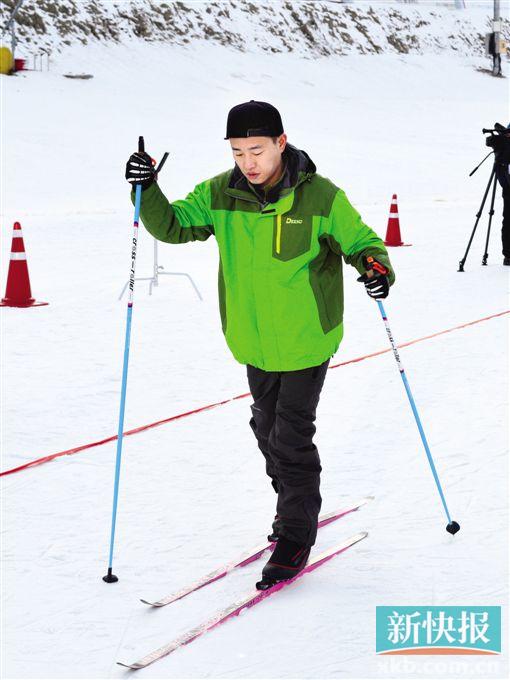 ■姜gary身穿绿色滑雪服,脚踩双板架势十足。