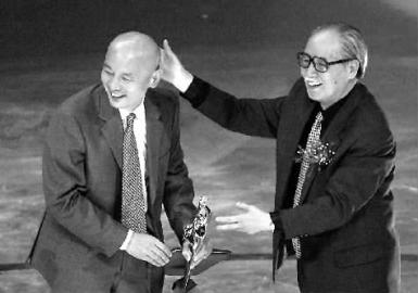 2002年，葛存壮（右）在为葛优颁发百花奖奖杯 新华社 发