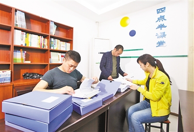 3月6日，两江名居公租房社区，志愿者利用周末时间整理受助学生的档案资料。