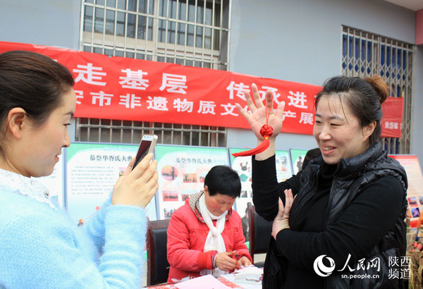 一位群众手持刚刚学会的结绳吊坠喜出望外   和冰摄