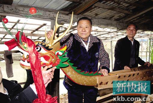 ■卢浩英在为龙舟装上“龙头”。