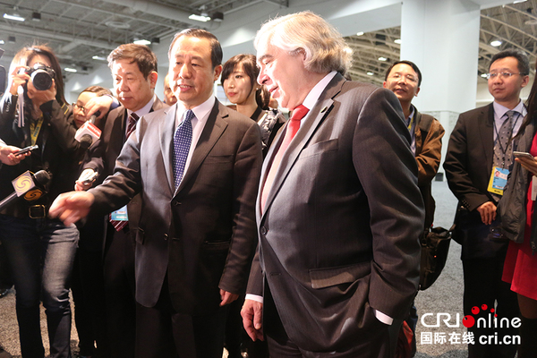 中国国家原子能机构主任许达哲向美国能源部长莫尼兹介绍中国展台。