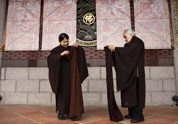 两位老人在整理衣服。（图片来源：美国在线）