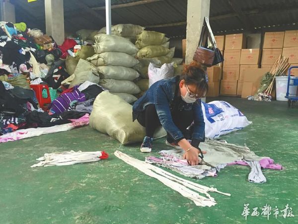 工作人员正在把部分不能捐赠的衣服制作成拖把。