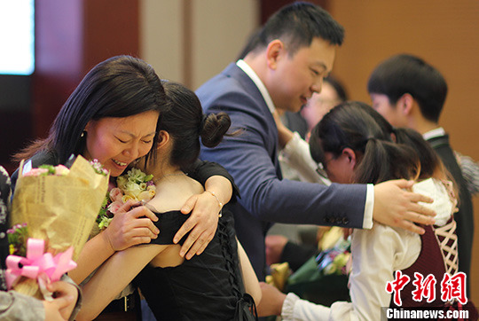 即将离开校园的高中毕业生在成人仪式上与家长拥抱。 中新社记者 泱波 摄 4月15日,南京雨花台中学国际部2016届毕业典礼暨成人仪式在雨花台中学举行,跨入18岁、即将奔赴世界各地名校的学生们与家长手牵手共同走过青春之门,并向国旗宣誓,同时载着满满的祝福告别老师,开始迎接新的学习生活。