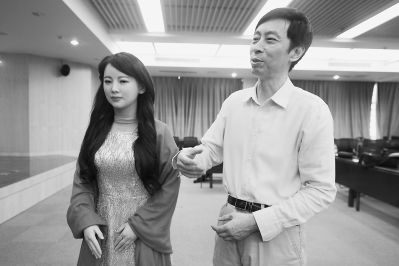 15日，在位于安徽合肥的中科大校园，中科大陈小平教授（右）在介绍机器人“佳佳”。