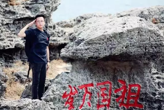 周小平在石岛老龙头礁石旁向祖国敬礼。曲延涛摄