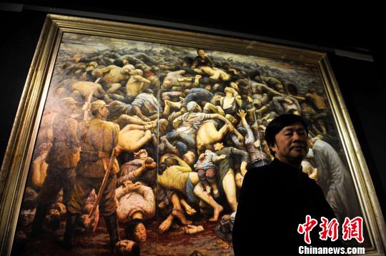 图为李自健和他的作品《南京大屠杀》　刘冉阳　摄
