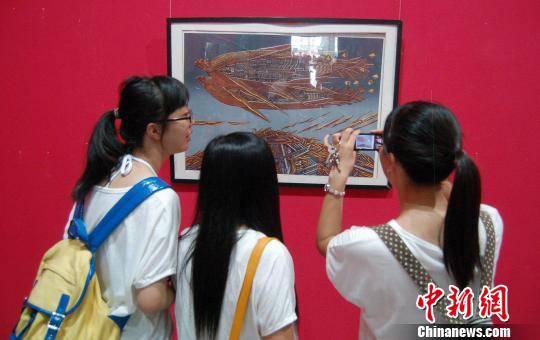图为市民参观“首届中国工业版画三年展”。　张芹　摄