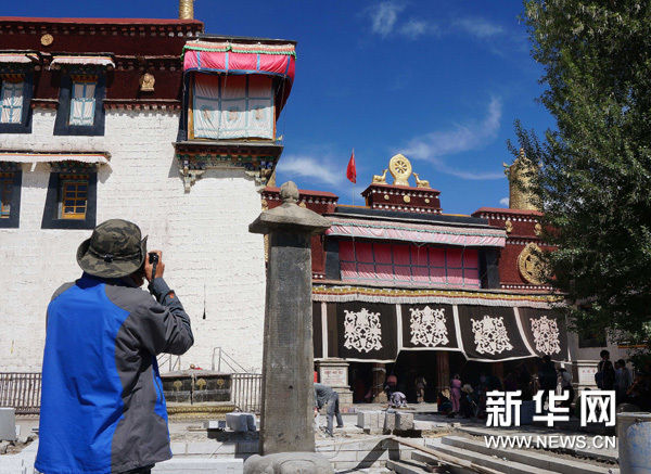 一名游客正在拍摄大昭寺门前的唐蕃会盟碑（6月4日摄）。新华网图片 王昀加 摄