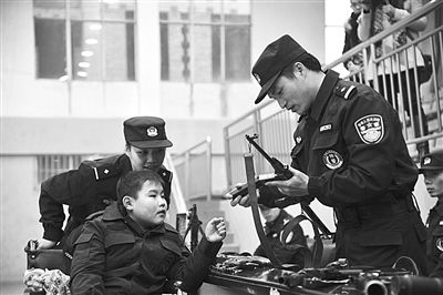 小骏億在江西新余市公安局特警支队观摩枪械。