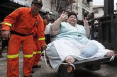 泰最胖女三年未出门 政府爆破房子让其通行

泰国一名妇女体重高达274公斤，是泰国最胖的妇女。她3年都呆在公寓中，足不出户。不过，2010年8月26日，她在一辆铲车的帮助下，头一次离开了公寓。据悉，这名时年40岁的泰国妇女Umnuayporn Tongprapai在邻居们的帮助下，联系了曼谷市镇当局，她需要离开自己的公寓去医院做手术，以便移除右腿上的一个肿瘤。这名妇女说，她靠自己的力量走路，只能走几米远，于是很少出门。但是现在，她需要上医院看病。当局召集了工程师、爆破专家、医护人员前往协助这名妇女出门。

