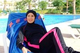 穿着穆斯林泳装“burkini”的女子在沙滩椅上晒太阳。