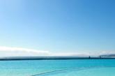 4月8日，在智利中部海滨城市阿尔加罗沃，两名儿童在号称目前世界最大人工游泳池边的沙滩上玩耍。这个游泳池位于阿尔加罗沃市圣阿方索德尔玛度假村，长1013米，总面积达8公顷，可容纳25万立方米的水，相当于6000个标准的家用泳池，游客甚至可以在里面泛舟。游泳池使用的是自然流通的海水，夏天时温度可保持在26摄氏度，清澈蔚蓝的池水让人心旷神怡。该游泳池已被载入吉尼斯世界纪录。新华社记者叶书宏摄