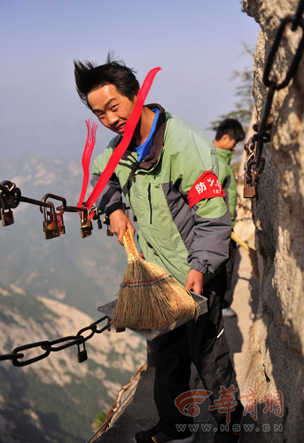 险峻华山上的环卫工 身系绳索在悬崖上拾垃圾