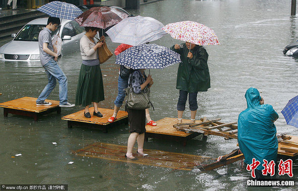 武汉暴雨致多处渍水 市民过路招数多