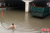 2012年6月10日18时左右，湖南株洲市建设北路杉木塘涵洞，朝北方向，一辆本地牌照小车被彻底淹没，司机坦言，自己是本地人，明知此处逢水必淹，但仍心存侥幸，结果是连手机都没抢救出来，全部被淹。而在杉木塘涵洞，朝南方向，一辆江西牌照货车被浸泡，三人被困，不久其中一人下水游出，方才脱困。泊伟 摄 图片来源：CFP视觉中国

