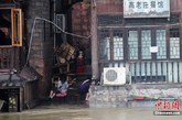 6月27日，大水淹没了湖南凤凰古城沱江两边的吊脚楼一层，一些居民坐在家门口洗菜。25日晚开始，湘西凤凰古城突降暴雨，一直持续了12个小时。