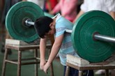 据一位北京队教练介绍，每名运动员在退役时大概可以得到一年一万元左右的退役费，显然对于错过了学习年龄的女举重选手们来说，这些是不够的。训练结束后一个孩子累的挂在杠铃上。

