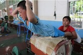 一年之前的一项调查显示，中国目前有100多个举重训练基地，分布在各省市体校、运动队等单位。其中，女子举重基层队伍的架构基本与男子相同。两个孩子互相压腿训练腰背肌肉。

