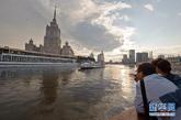 8月18日，游客在莫斯科河中行驶的一艘游船上欣赏沿途风景。在俄罗斯首都莫斯科，蜿蜒迂回的莫斯科河穿城而过。每逢莫斯科河的通航季节，乘船游览莫斯科便成为许多游客的首选。游客沿途不仅可以看到克里姆林宫、俄罗斯联邦政府大楼、高尔基文化公园、麻雀山、莫斯科大学主楼、救世主大教堂等莫斯科主要建筑及景点，而且还可以在船上品尝俄罗斯美食，尽享悠闲时光。新华社记者姜克红摄
