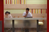 7月31日上午，KFC中山亭店内，一位市民正在看着报纸。