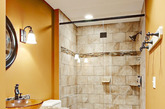 同样的狭长户型，但是不同的是卫浴间的风格进行了创新，一改白色墙面的设计，采用暖黄色打底，淋浴房内部和地面采用相同款式和分隔的地砖进行铺贴，很好的构建出具有点点罗马气质的小卫浴间。