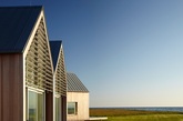 建筑位于美国罗德岛海岸，由享负盛名的Roger Ferris and Partners建筑事务所设计。沿着40英尺长的木制坡道通往几个看似相互独立的尖顶房屋，其设计灵感正是来源于传统的船篷外形。（实习编辑）
