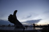 2013年9月26日，山东乳山，银滩的地标建筑大拇指广场雕塑下，来自天津的陈先生在练习甩鞭子。冬季天冷的时候，他就要回到老家。
（实习编辑：容少晖）