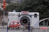 2月6日，重庆市民正经过“照相机”公厕。创意“照相机”厕所亮相重庆石桥铺数码城，以“照相机”外形来修建的公共卫生间，成为一道创意城市风景线。图为市民正经过“照相机”公厕。