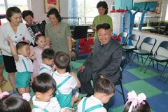 金正恩看望儿童指导喂食蜂蜜