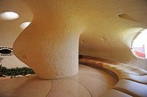 墨西哥建筑师Javier Senosiain在2006年为一个年轻的家庭设计了这座巨型的鹦鹉螺贝壳屋 。从外面沿着一道层层递升的楼梯走上前，你可以通过一大扇彩色玻璃墙边的一角开门进入贝壳屋。迎门的右手边有一片花朵般的沙发休息区 ，周围尽是郁郁葱葱的植被；前方是餐厅和餐厅；沿着蜿蜒曲折的螺旋楼梯继续探索，还有独特的电视室、工作室，以及私密的卧室等有趣和别致的生活空间。（实习编辑：刘宁馨）