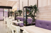 咖啡店和面包店多以暗色原木装点，而位于墨尔本的这家咖啡店兼面包店别出心裁，明色的原木，加入紫色元素：紫色沙发、紫色灯罩，再点缀以紫色花卉，轻盈活泼，给人营造一种浪漫的氛围。