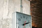 混凝土墙面上一块德国工厂悬挂的钟表。